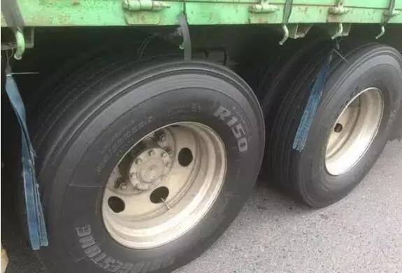 为什么有些大货车轮胎旁边都绑一些皮条？